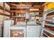 Functional utility area with a washer, dryer, water heater, and shelving for storage at 7051 Dartmouth N Ave, St Petersburg, FL 33710