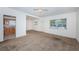 Spacious carpeted living room with white walls, ceiling fan and natural light at 7051 Dartmouth N Ave, St Petersburg, FL 33710