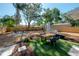 Spacious backyard with a dining set, green artificial turf, and mature trees, perfect for outdoor entertaining at 7311 N Dartmouth Ave, Tampa, FL 33604