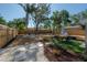 A backyard with a lawn, a sitting area, mature trees and a wood fence at 7311 N Dartmouth Ave, Tampa, FL 33604