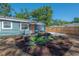 Backyard with patio seating area and wood fence, enhanced by colorful landscaping at 7311 N Dartmouth Ave, Tampa, FL 33604