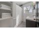 Bright bathroom featuring a shower, sink, and open shelving for towels at 7311 N Dartmouth Ave, Tampa, FL 33604