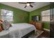 Bedroom with ceiling fan, stylish decor, and hardwood flooring at 7311 N Dartmouth Ave, Tampa, FL 33604