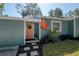 Home featuring a charming front door, vibrant landscaping and sidewalk at 7311 N Dartmouth Ave, Tampa, FL 33604