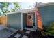 Covered front porch with decor, a colorful door, and well manicured landscaping at 7311 N Dartmouth Ave, Tampa, FL 33604
