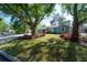 Inviting home exterior with lush green grass, mature trees providing shade, and vibrant red landscaping around the property at 7311 N Dartmouth Ave, Tampa, FL 33604