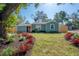 Charming single-story home with a manicured lawn and vibrant red landscaping, creating a welcoming curb appeal at 7311 N Dartmouth Ave, Tampa, FL 33604