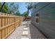 Side yard featuring gravel and stone path along the house and wood fence at 7311 N Dartmouth Ave, Tampa, FL 33604