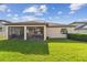 Expansive backyard featuring a screened-in lanai, a well-maintained lawn, and privacy landscaping at 8248 Sequester Loop, Land O Lakes, FL 34637