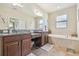 Well-lit bathroom featuring dual vanities, tiled floors, and a separate bathtub at 8248 Sequester Loop, Land O Lakes, FL 34637