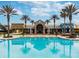 Community clubhouse with a bright blue swimming pool, palm trees, and a welcoming entrance for residents at 8248 Sequester Loop, Land O Lakes, FL 34637