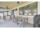 Covered screened lanai boasts a ceiling fan, dining table, grill, and comfortable seating area for outdoor enjoyment at 8248 Sequester Loop, Land O Lakes, FL 34637