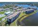 Breathtaking aerial view of condos near the water, featuring a pool and tennis courts at 8251 Brent St # 941, Port Richey, FL 34668