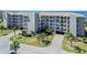Aerial view of multi-story condo with attractive landscaping and parking at 8251 Brent St # 941, Port Richey, FL 34668