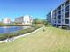 Scenic view of community lake, manicured lawn, sidewalks, and complex at 8251 Brent St # 941, Port Richey, FL 34668