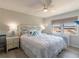 Bright bedroom with coastal decor, ceiling fan, and water view at 8251 Brent St # 941, Port Richey, FL 34668