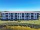 The exterior aerial shot presents a multi-story condominium complex with well-maintained landscaping at 8251 Brent St # 941, Port Richey, FL 34668