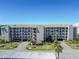 Full exterior shot of condo building featuring multiple units, covered parking, and landscaping at 8251 Brent St # 941, Port Richey, FL 34668