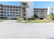Multi-story condo building featuring balconies, landscaped grounds, and covered parking at 8251 Brent St # 941, Port Richey, FL 34668