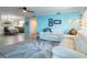 Bright living room with blue accent wall, hardwood floors, modern furnishings, and a view to the dining room at 8251 Brent St # 941, Port Richey, FL 34668