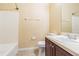 Neutral bathroom features a tub with shower, tiled walls, toilet, and vanity sink at 8341 Shallow Creek Ct, New Port Richey, FL 34653