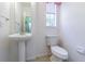 Clean bathroom with pedestal sink, window, and tile floors at 8341 Shallow Creek Ct, New Port Richey, FL 34653