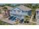 Light blue townhome with front-facing garages, second-story balconies, and lush palm tree landscaping at 8341 Shallow Creek Ct, New Port Richey, FL 34653