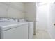 Bright laundry room with modern washer, dryer, tile flooring, and convenient shelving at 8341 Shallow Creek Ct, New Port Richey, FL 34653