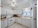 Bright, white kitchen with a window over the sink and lots of storage at 9945 47Th Ave N # 203, St Petersburg, FL 33708