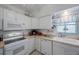 Kitchen with white appliances, countertops, cabinets, and tile flooring at 9945 47Th Ave N # 203, St Petersburg, FL 33708