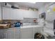 Convenient laundry room features a washer, dryer, lots of cabinet space, and a utility sink at 9945 47Th Ave N # 203, St Petersburg, FL 33708