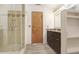 This modern bathroom has a glass shower, wooden cabinets, neutral tiling, and wood-look flooring at 1054 13Th S Ave, St Petersburg, FL 33705