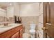 Cozy bathroom with wood cabinets, tile floor and walls, and a toilet with wood door at 1054 13Th S Ave, St Petersburg, FL 33705