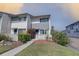 Charming condo with lush landscaping, light gray paint, blue doors, and walkway at 14800 Walsingham Rd # 301, Largo, FL 33774