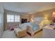 Cozy main bedroom featuring a comfortable bed, sitting area, and natural light at 14800 Walsingham Rd # 301, Largo, FL 33774