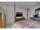 Comfortable main bedroom featuring wood post bed, patterned bedding, tv, dresser, and double door closet at 14800 Walsingham Rd # 301, Largo, FL 33774