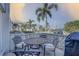 Outdoor patio with a table and chairs and a view of palm trees and the building at 14800 Walsingham Rd # 301, Largo, FL 33774