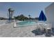 Community pool area with lounge chairs, tables, and palm trees at 14800 Walsingham Rd # 301, Largo, FL 33774