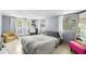 Bright bedroom with a bed, chair, desk, mirror and windows to let natural light in at 1591 S Prospect Ave, Clearwater, FL 33756