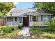Charming single-story home with a red door, stone path, and manicured landscaping at 1591 S Prospect Ave, Clearwater, FL 33756