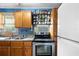 The kitchen features stainless steel appliances, a stove, a refrigerator, and wooden cabinets for storage at 1591 S Prospect Ave, Clearwater, FL 33756