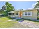 View of home showcasing a covered porch, orange front door, and verdant lawn at 1601 24Th S St, St Petersburg, FL 33712