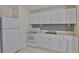 Efficient kitchen featuring white cabinetry, matching appliances, and a mosaic backsplash at 1601 24Th S St, St Petersburg, FL 33712