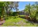 The backyard has a screen enclosed lanai with a pool surrounded by lush landscaping at 1819 Bella Casa Ct, Tampa, FL 33618