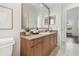 Bright bathroom features granite countertops, light wood cabinets, and a large mirror creating a comfortable and stylish space at 1819 Bella Casa Ct, Tampa, FL 33618