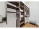 Spacious walk-in closet with dark wood shelving, a hanging rod, and a cushioned stool for comfort and convenience at 1819 Bella Casa Ct, Tampa, FL 33618