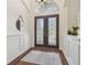 Elegant foyer featuring detailed double doors, wood floors, a decorative mirror, and a plant at 1819 Bella Casa Ct, Tampa, FL 33618