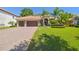 Charming home featuring a brick driveway, lush lawn, mature palm trees, and a three-car garage at 1819 Bella Casa Ct, Tampa, FL 33618