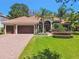 Beautiful single-story home with a well-manicured lawn and lush landscaping, featuring a three-car garage at 1819 Bella Casa Ct, Tampa, FL 33618