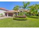 Beautiful home with a well-maintained lawn and sculpted landscaping, complemented by mature palm trees at 1819 Bella Casa Ct, Tampa, FL 33618